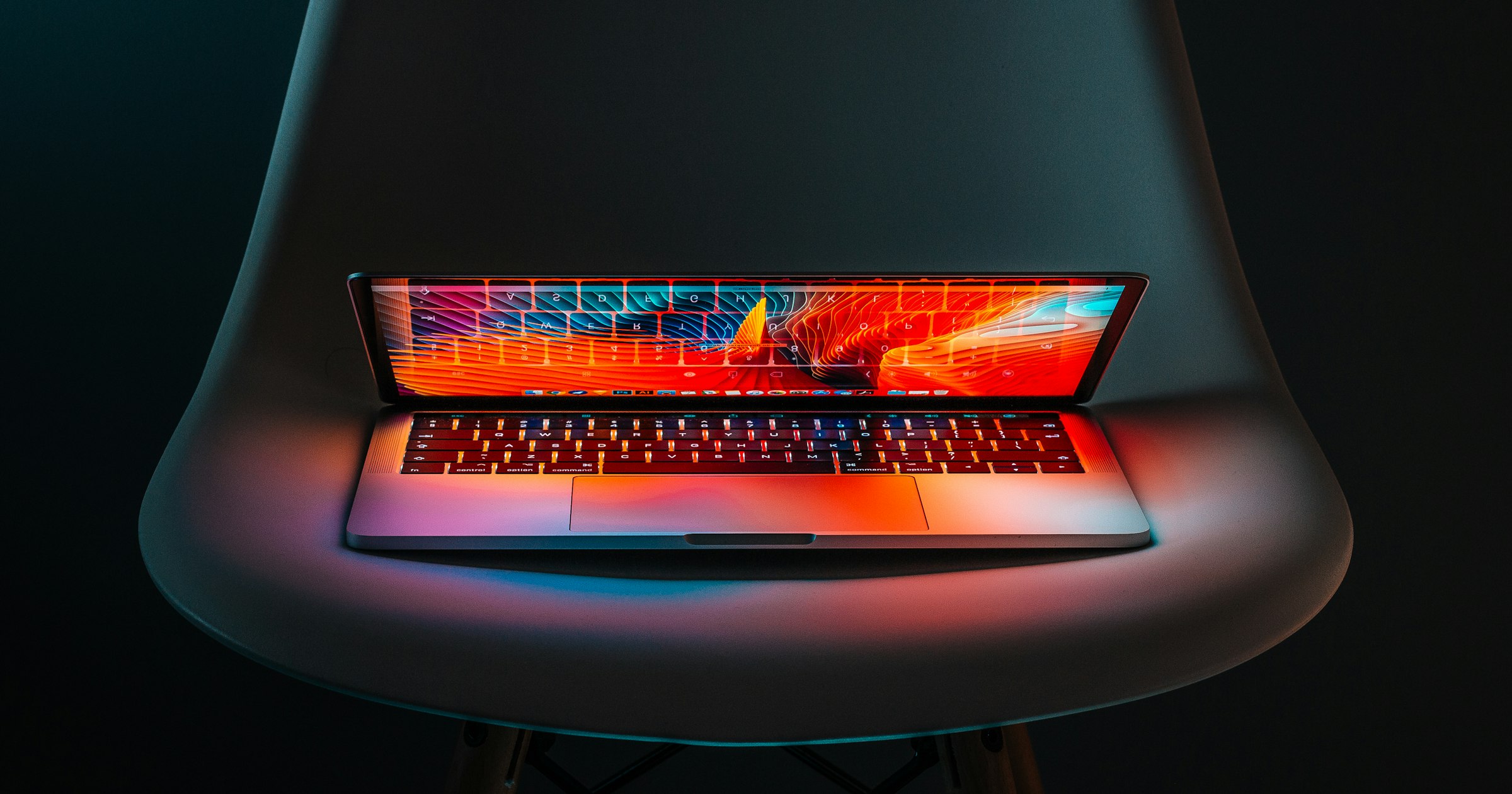 An open laptop glowing in a dark room