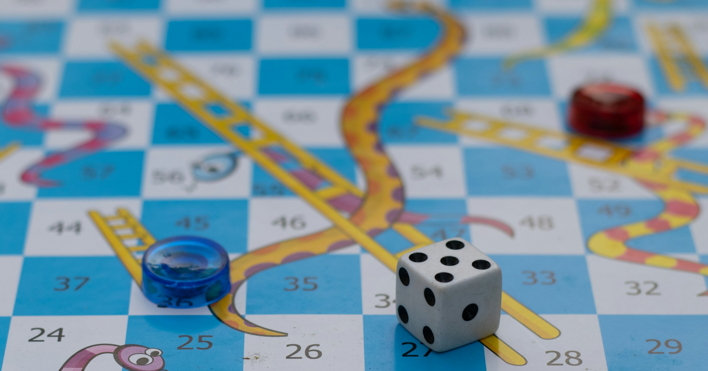 Game pieces and a die on a board game