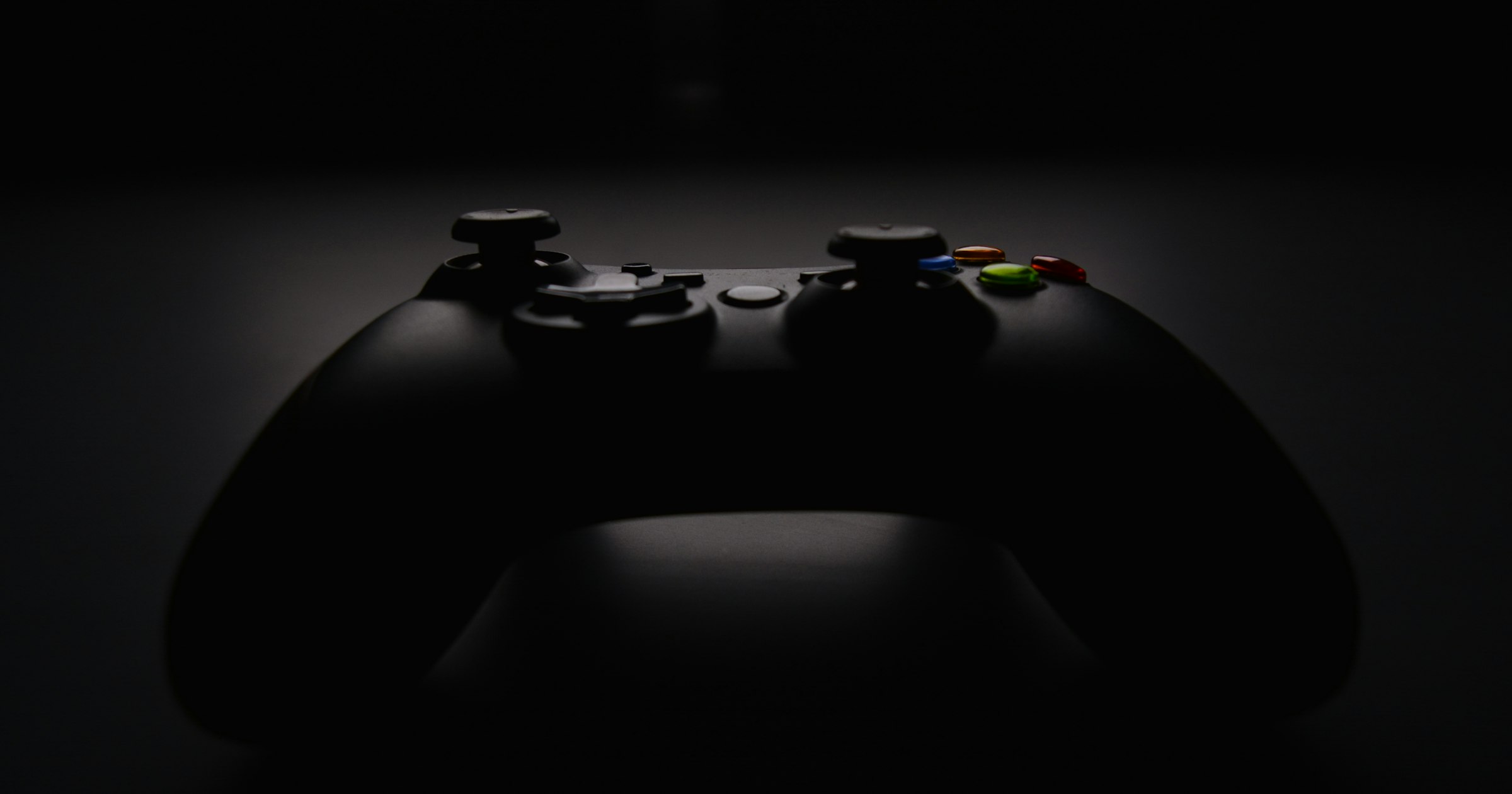 A video game controller lit against a dark background