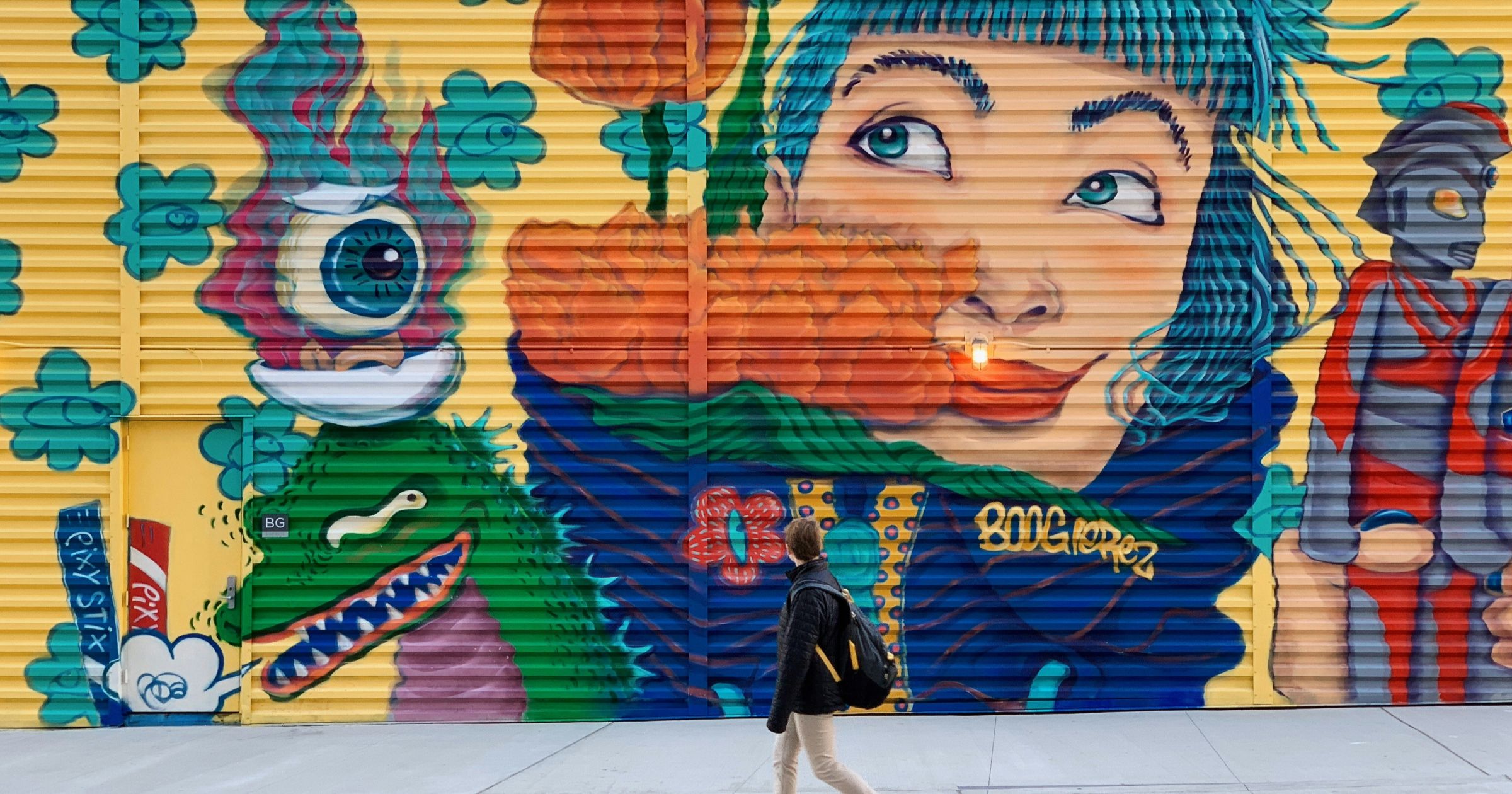 Colorful street mural with painted characters and a candy brand logo
