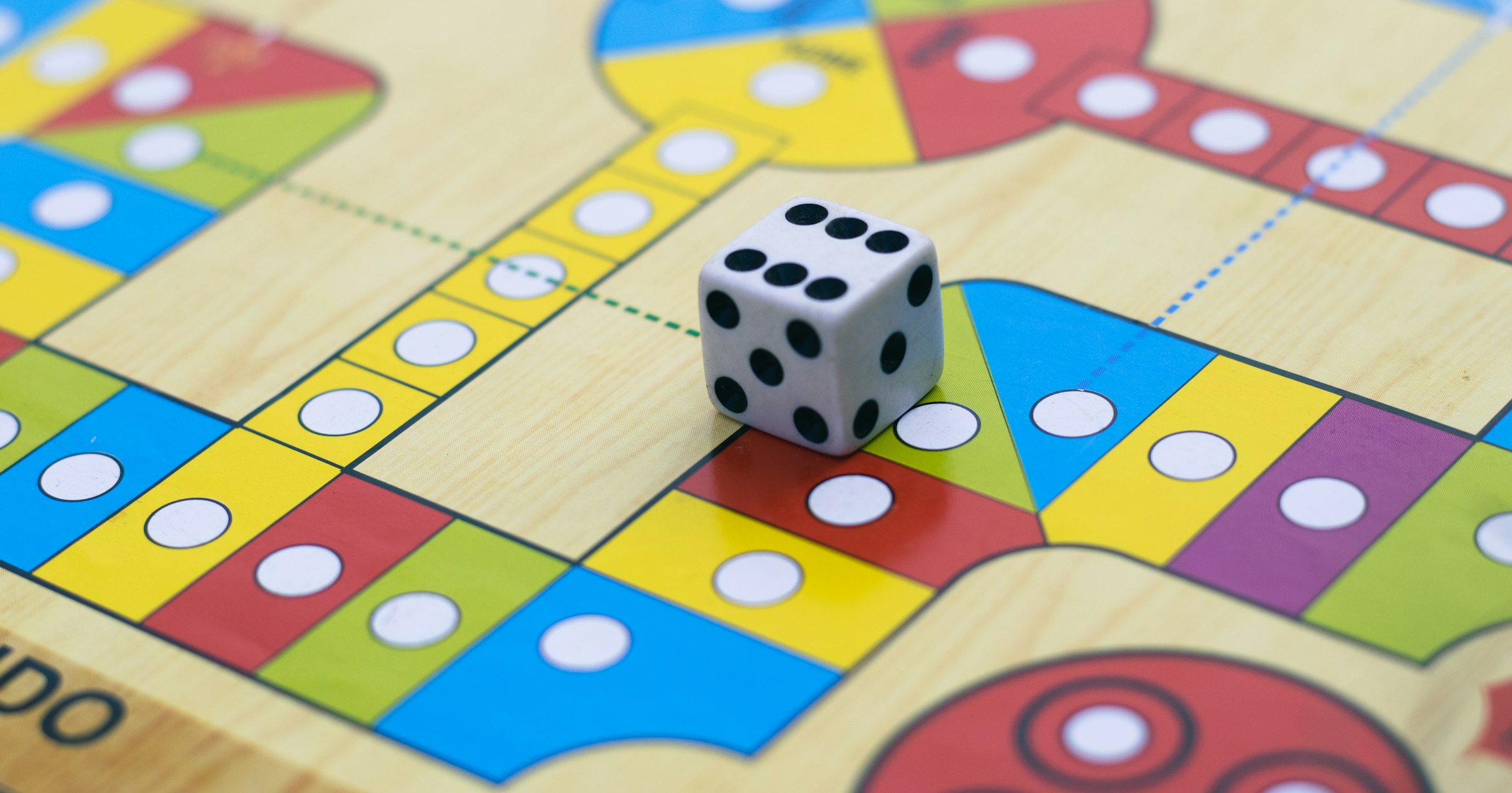 A die on a classic Ludo board