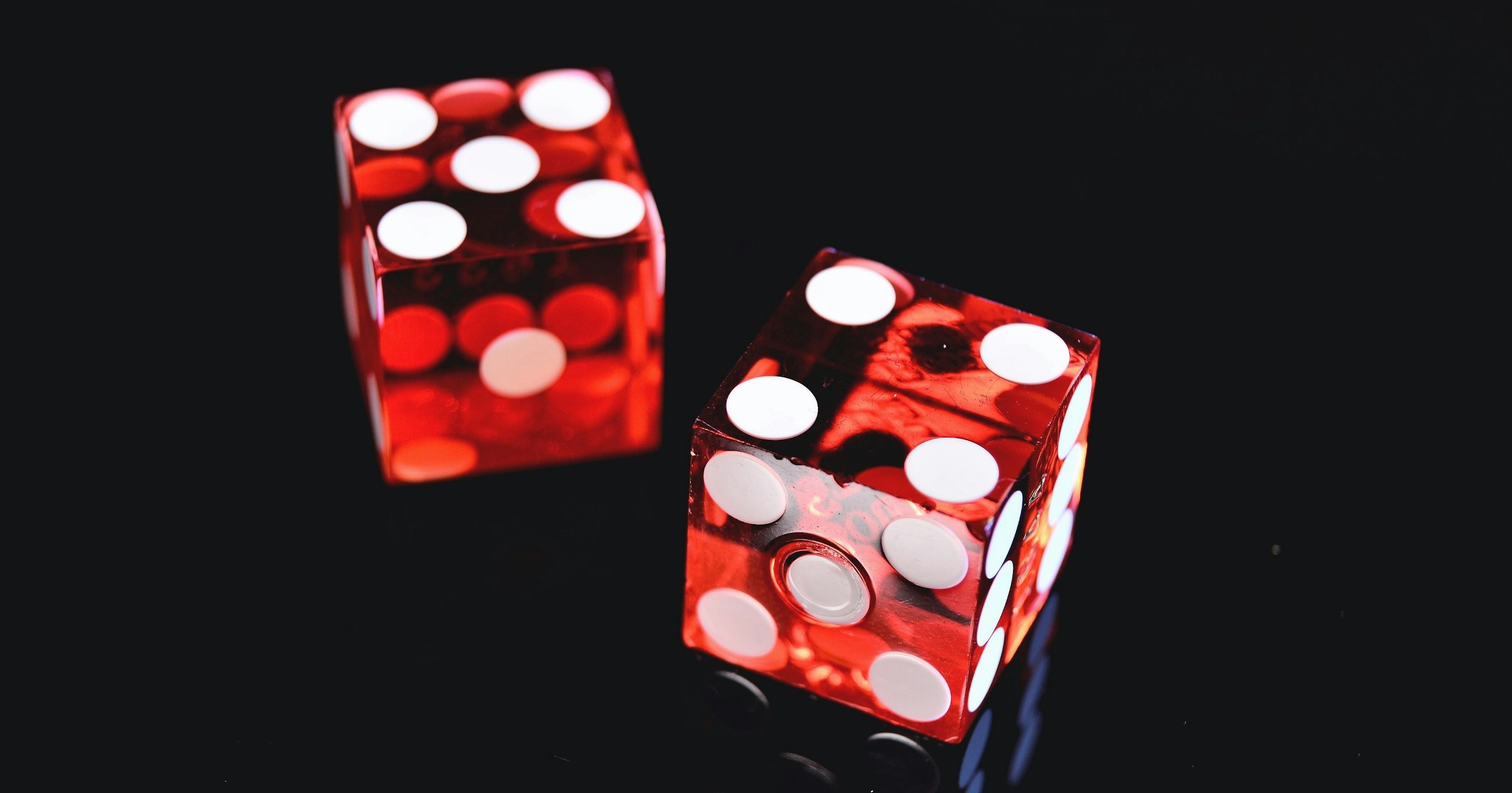 Two red dice on a dark background
